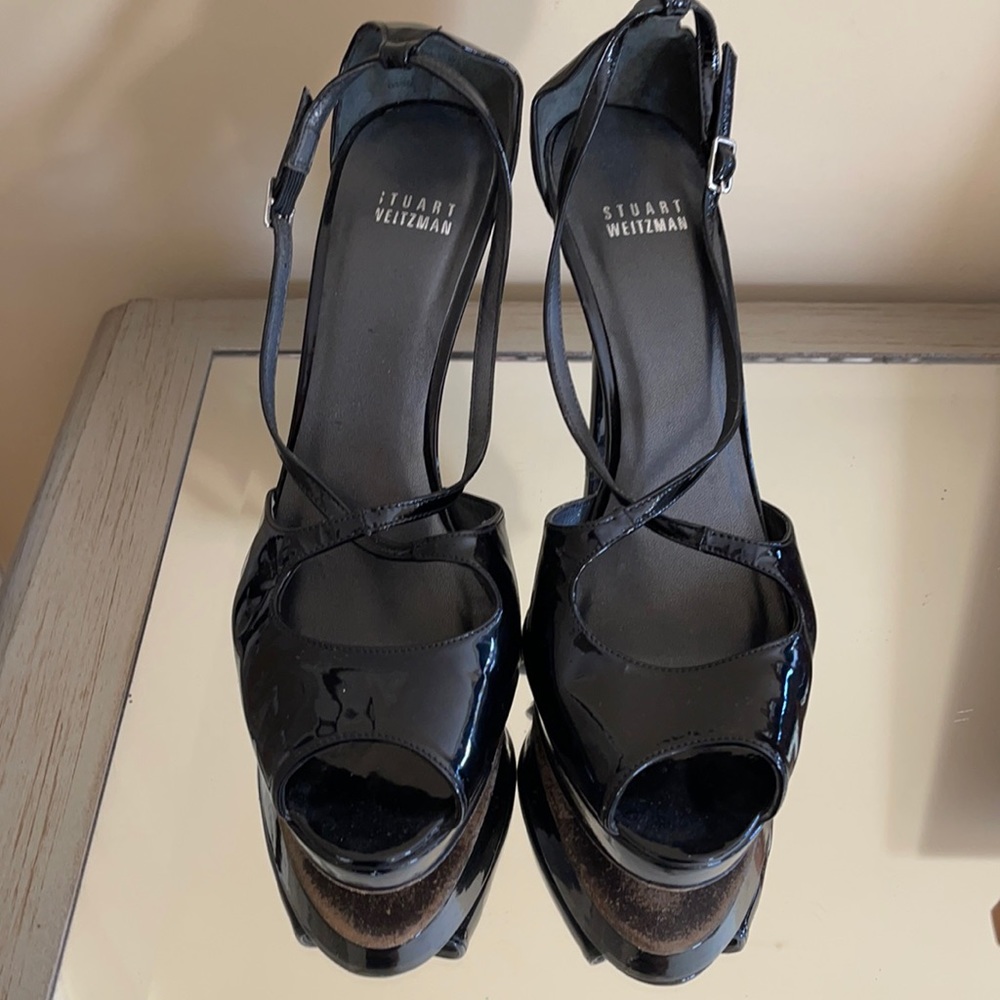 Stuart Weitzman black patent leather cross design straps heels.